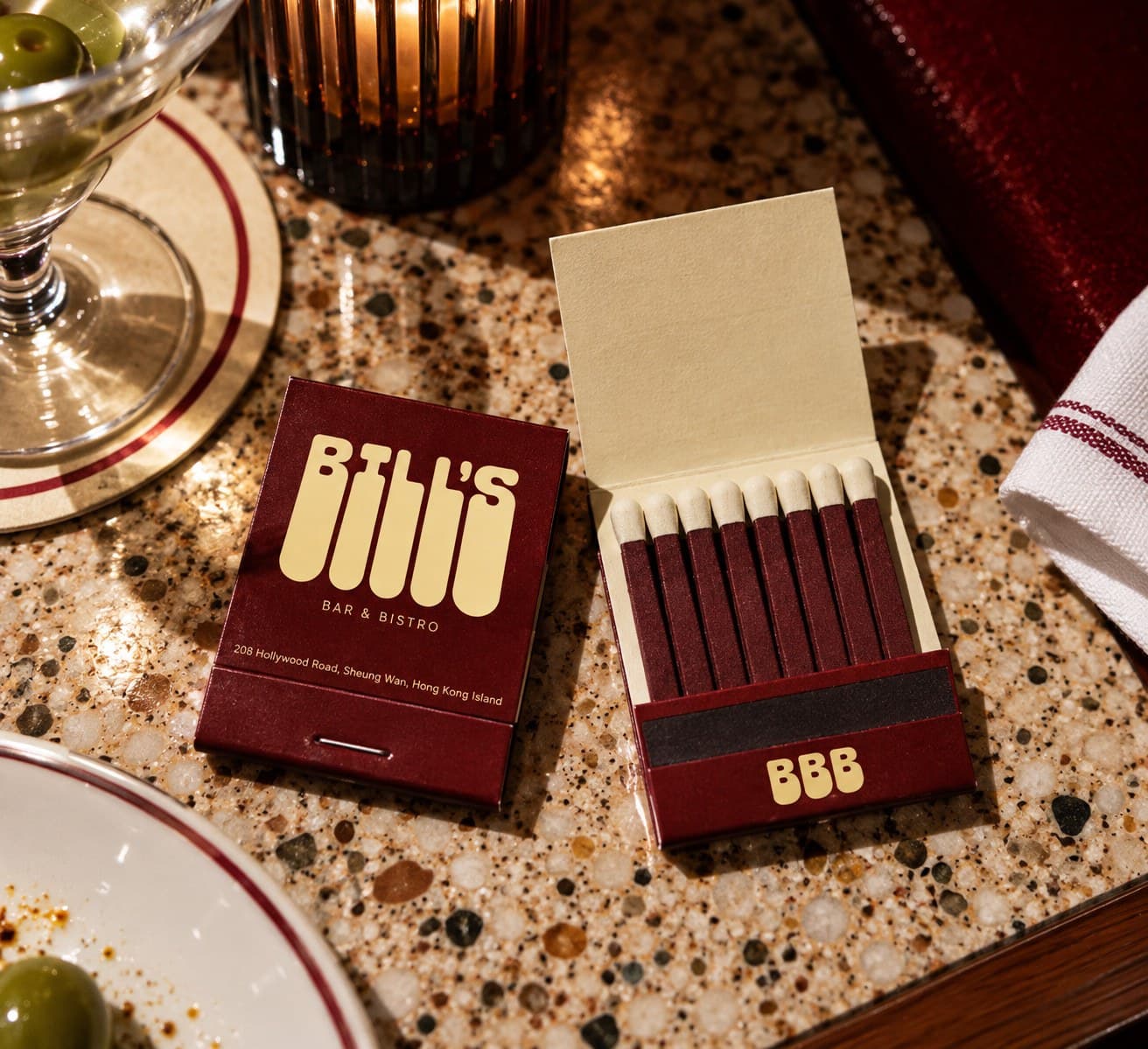 Bill’s matchbooks, one open, on a terrazzo table